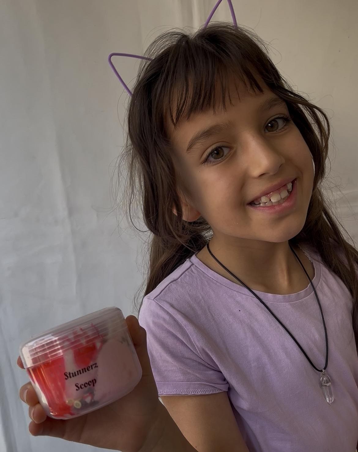 A smiling customer holding a Stunnerz Scoop slime